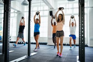 Fit people working out with weights in a gym
